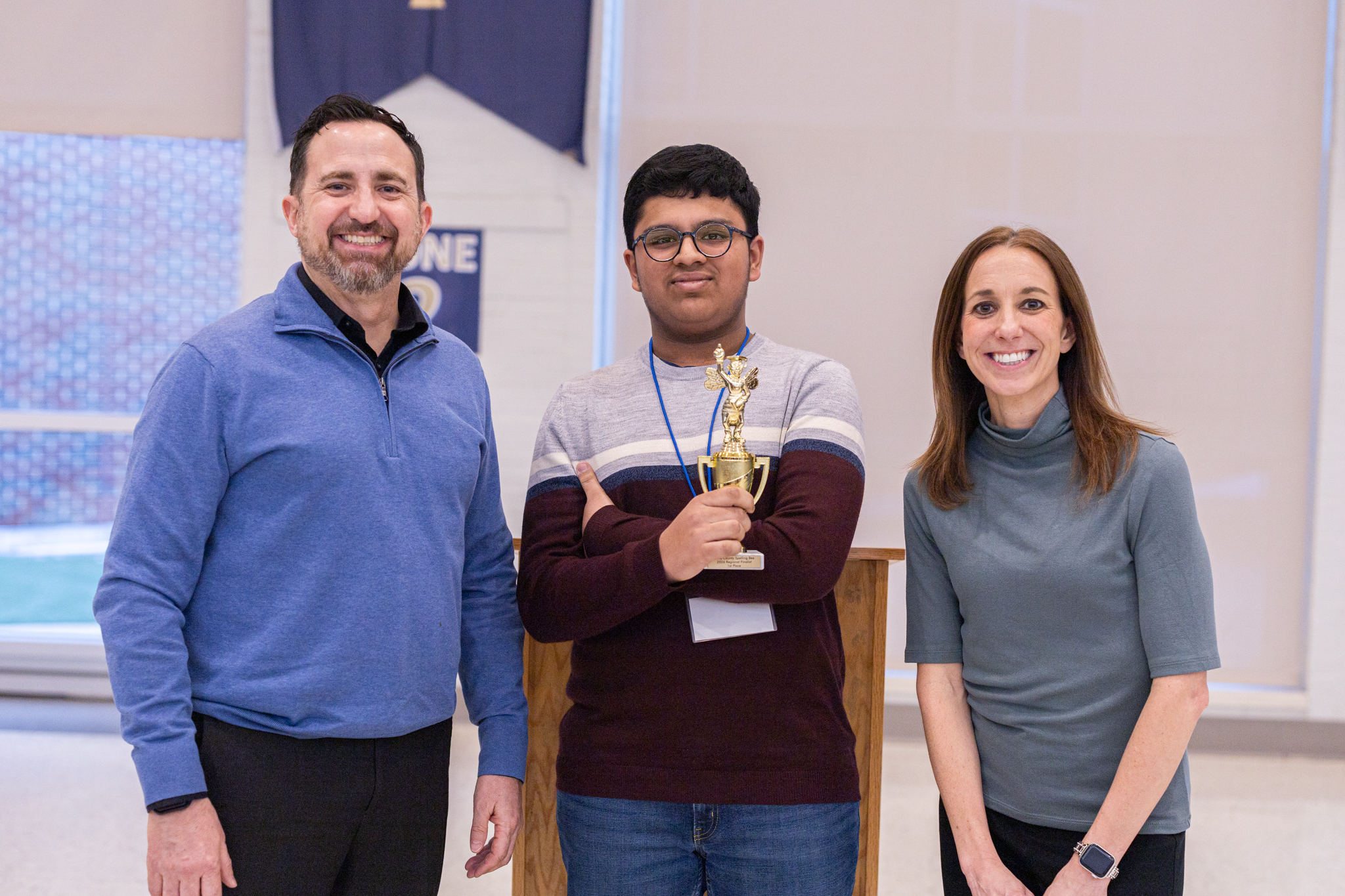 Winner of the 2026 Kane County Regional Spelling Bee holding their trophies with the Kane County Regional and Assistant Superintendents