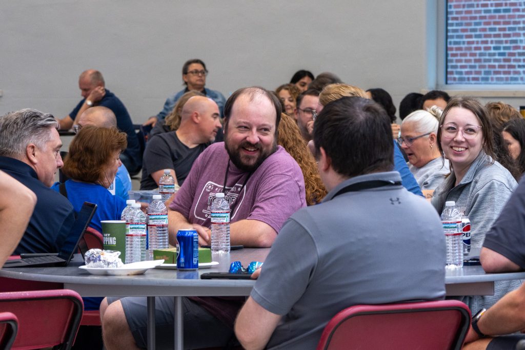 Professionals discussing at table during Kane County Tech Bash