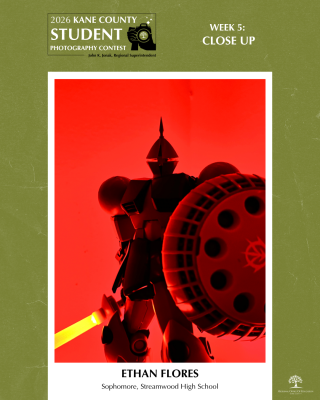 Close up of a robot action figure holding a shield and glowing sword standing intently against red background and lighting