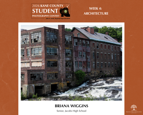 Old brick building with broken windows beside a flowing river