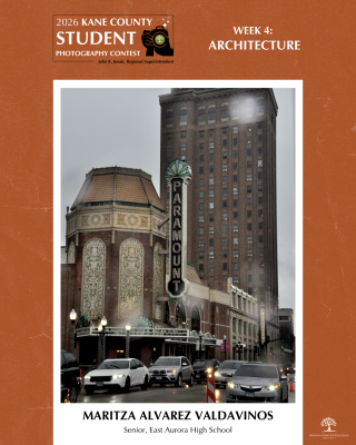 Paramount Theatre building with intricate marquee sign on a busy city street during a cloudy, rainy day